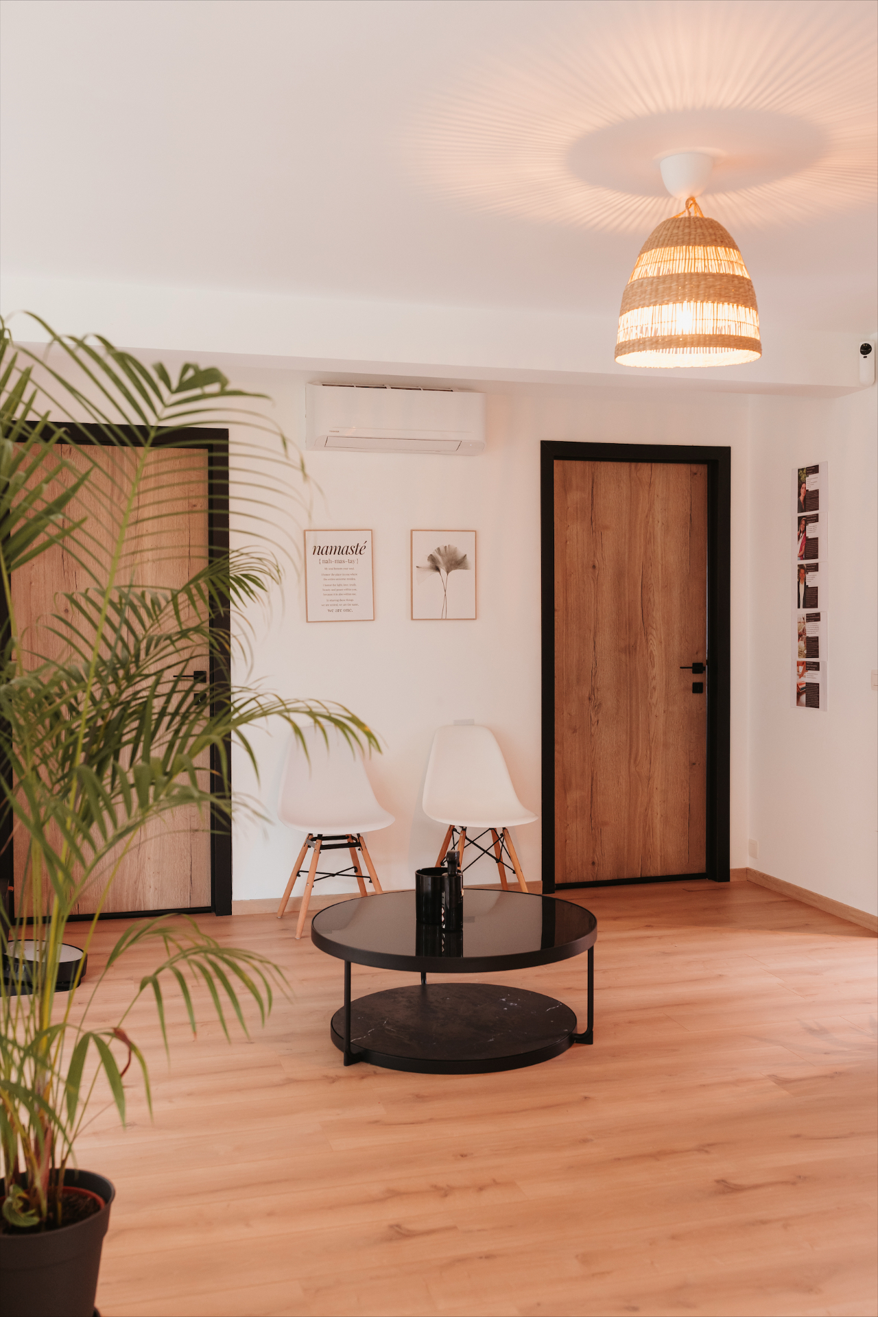 Espace d'accueil lumineux avec fauteuils, plante et affiche Namasté
